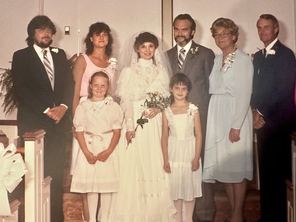 Wedding portrait of Shane and Lisa Ward with family at the church altar